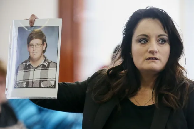Special prosecutor April Wilson holds up a photograph of Kenneth Suttner at the start of a coroner's inquest Tuesday at the Howard County Courthouse in Fayette.
